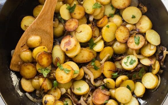 overhead image of lyonnaise potatoes in black skillet