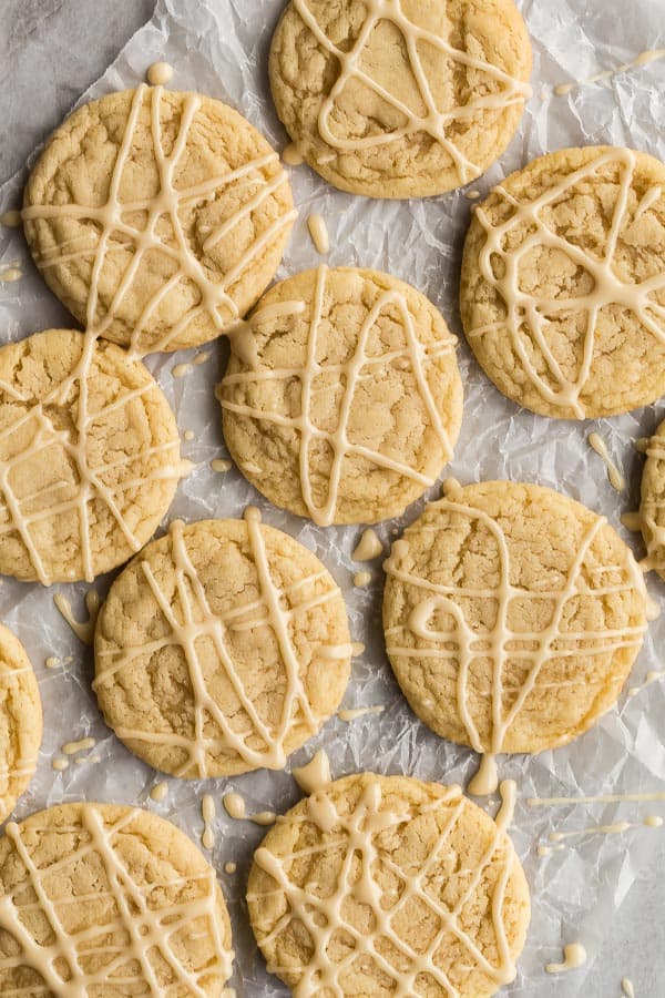 These Soft Maple Cookies are perfectly chewy and crispy on the edges, drizzled with an easy maple glaze! #cookies #cookie #baking #christmas overhead image of maple sugar cookies on wax paper