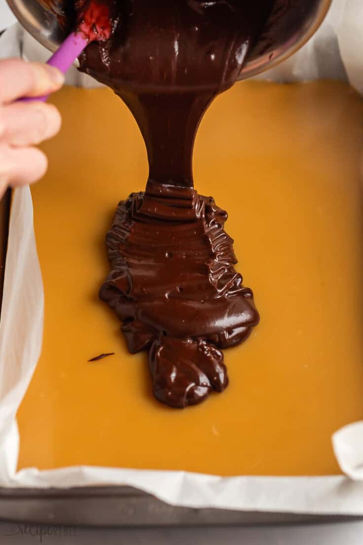 melted chocolate being poured on caramel.