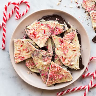 broken wedges of peppermint bark in a bowl with candy canes