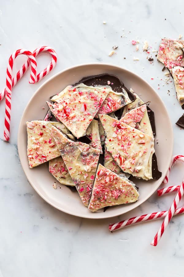 broken wedges of peppermint bark in a bowl with candy canes
