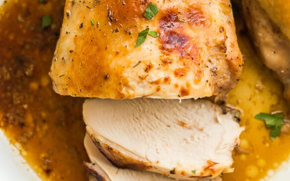 Overhead image of roast turkey breast in white baking dish