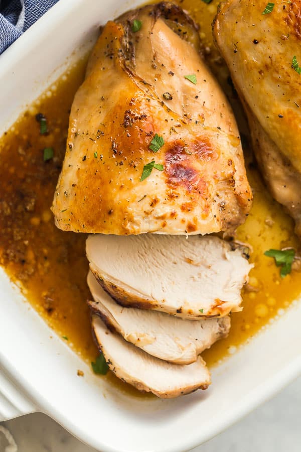 Overhead image of roast turkey breast in white baking dish