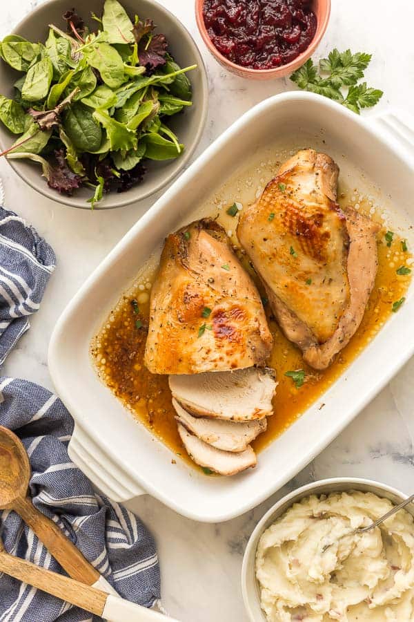 overhead image of roast turkey breast with salad and mashed potatoes