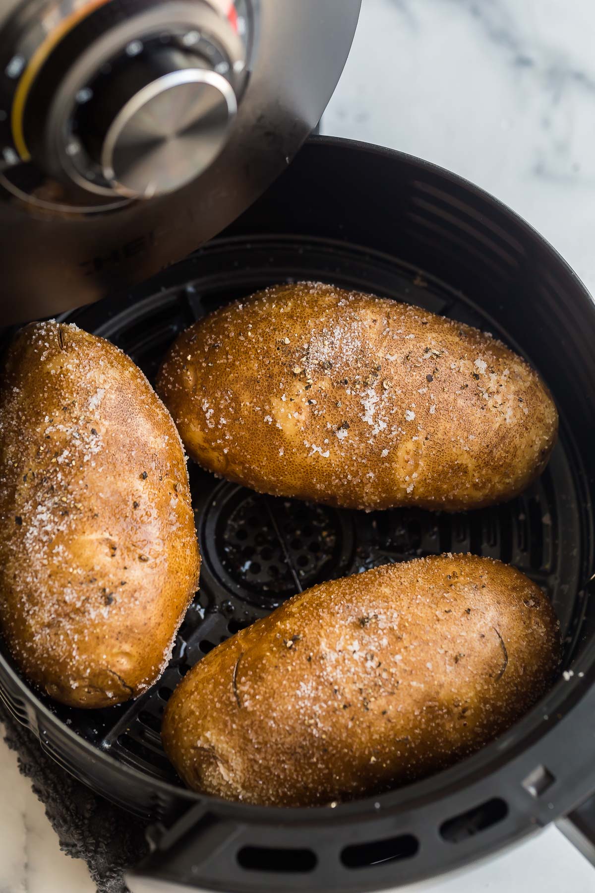 baked potatoes in air fryer basket.