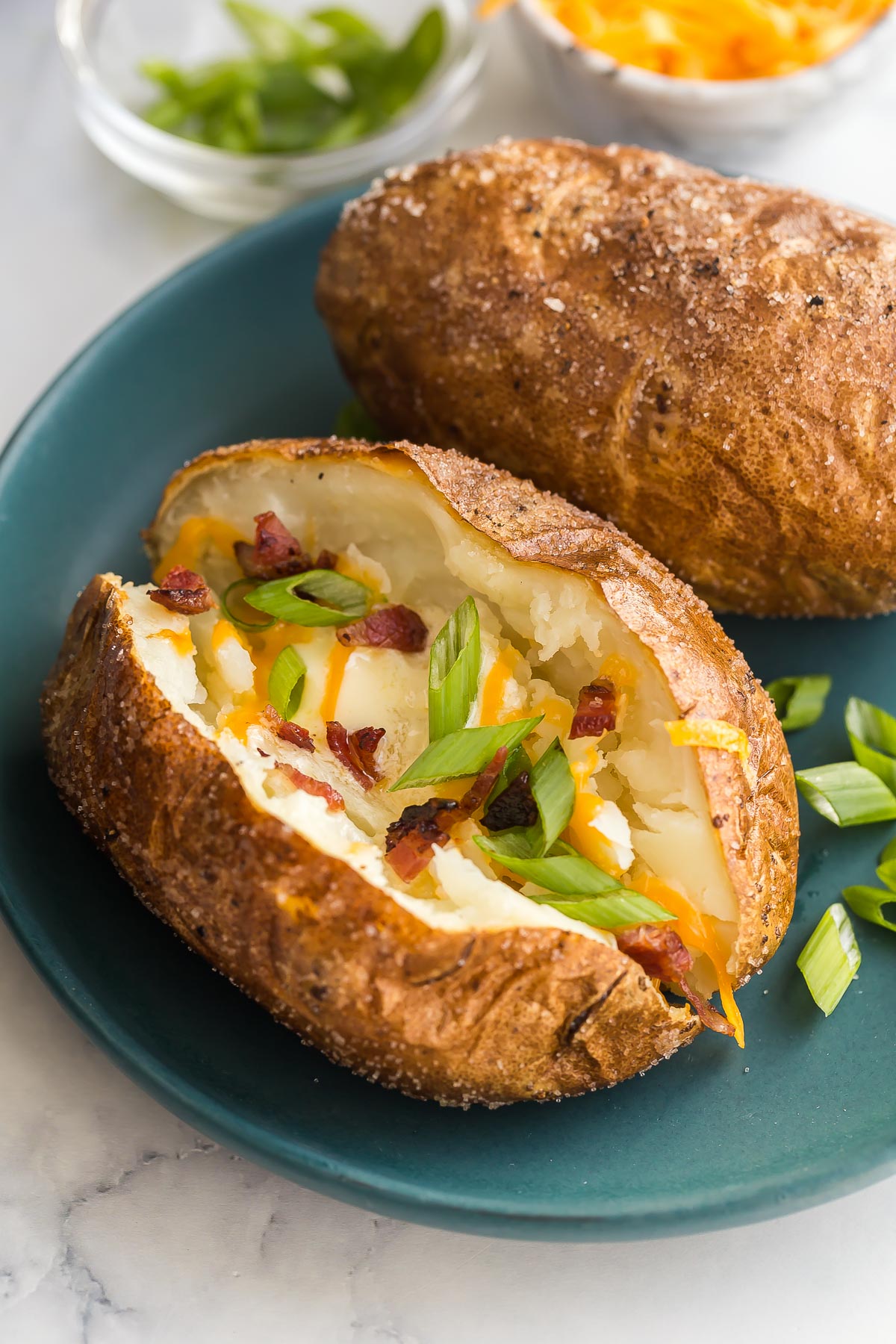 air fryer baked potato with toppings on blue plate.