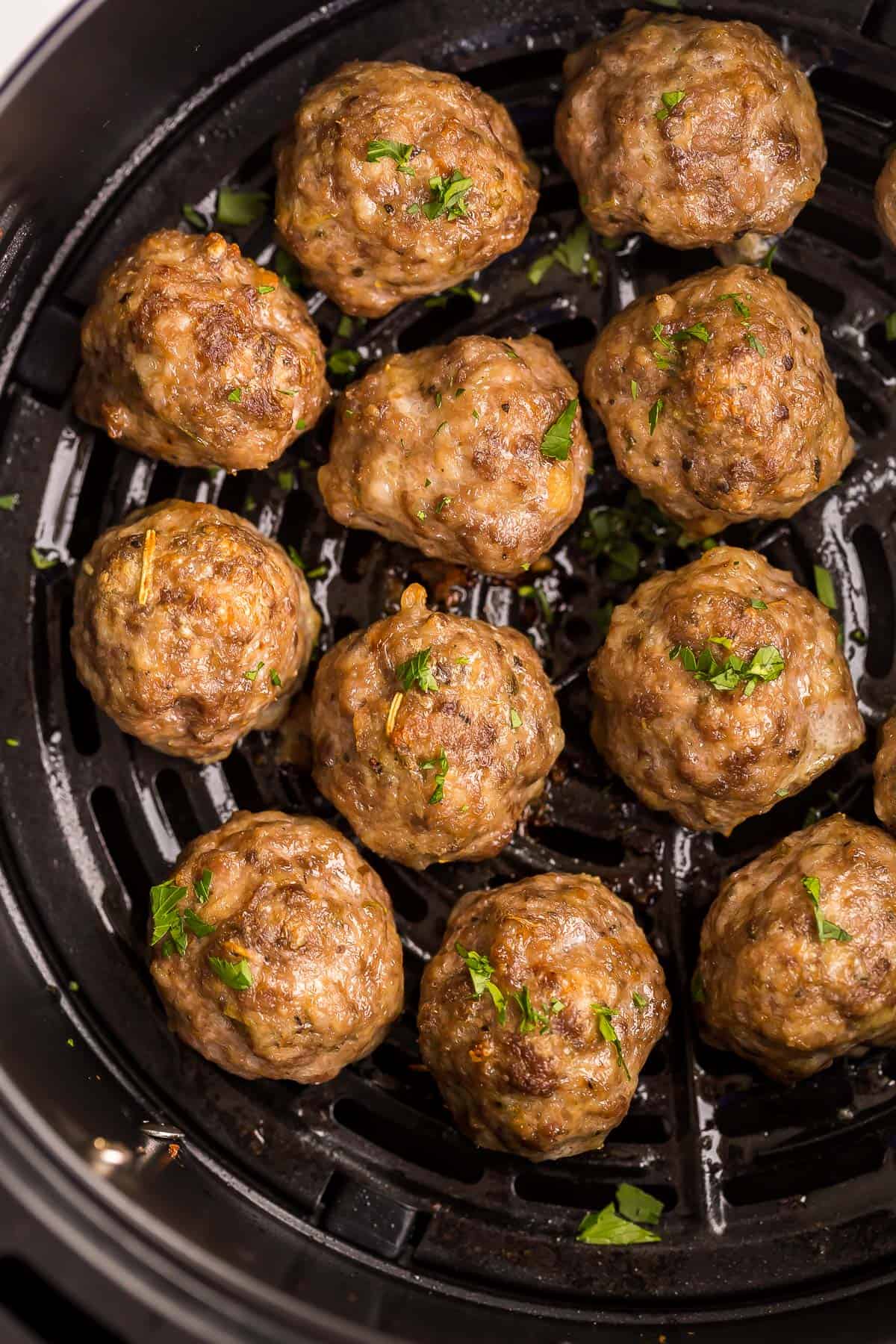 These Air Fryer Meatballs are a mix of beef, pork, Parmesan, and Italian seasoning for the perfect juicy bite. They cook up crispy on the outside and tender inside in just 20 minutes! #meatballs #airfryer #recipe | air fryer recipes | air fryer meals | homemade meatballs | beef meatballs | ground beef recipes | easy dinner ideas | quick meals overhead image of air fryer meatballs in air fryer basket.