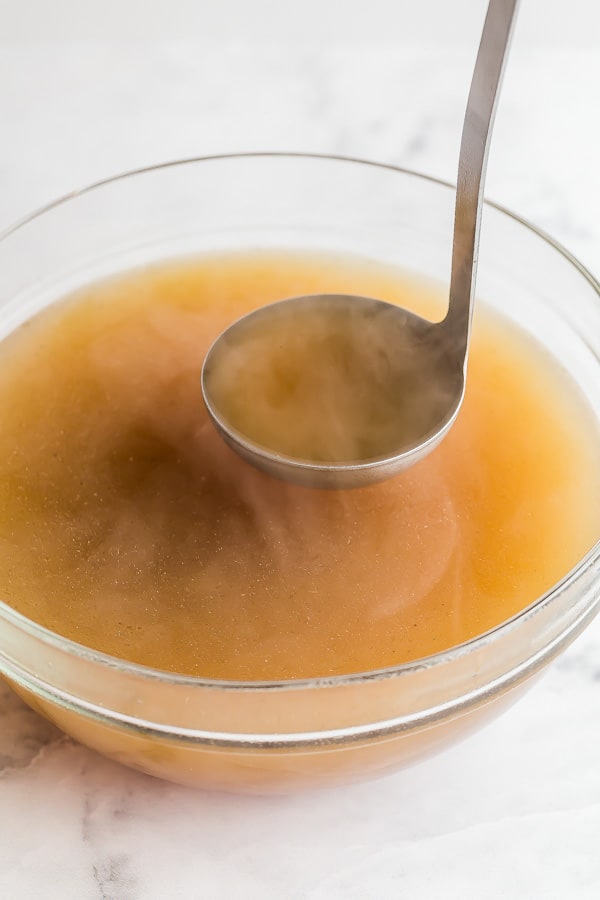 homemade chicken stock in large glass bowl