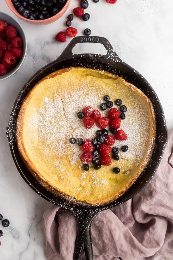 overhead image of dutch baby with powdered sugar and berries