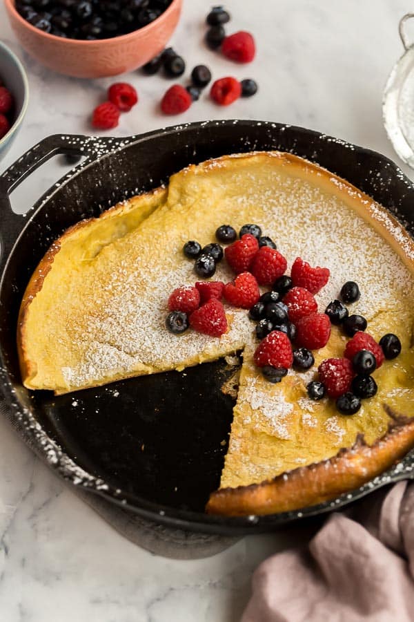 dutch baby in skillet with slice missing