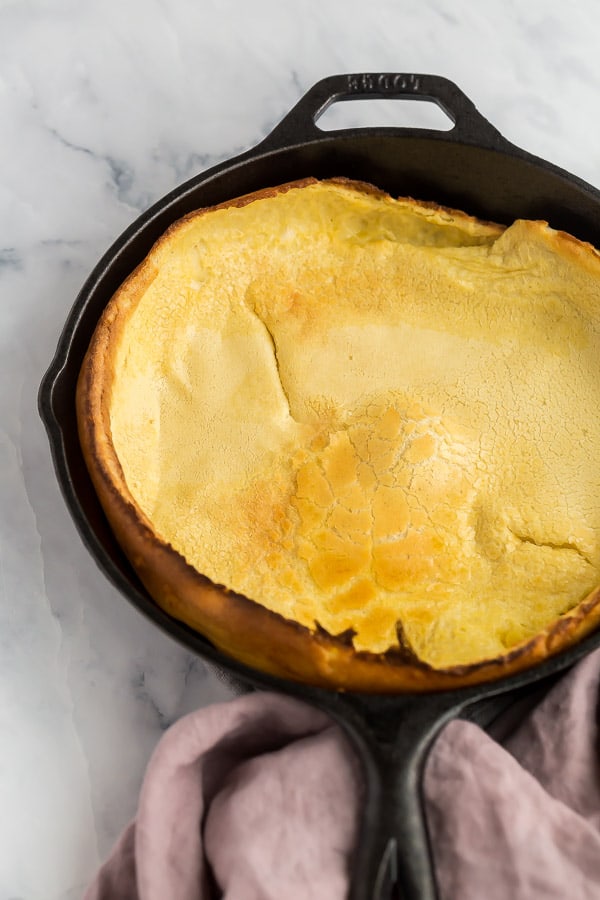close up image of dutch baby pancake in cast iron skillet