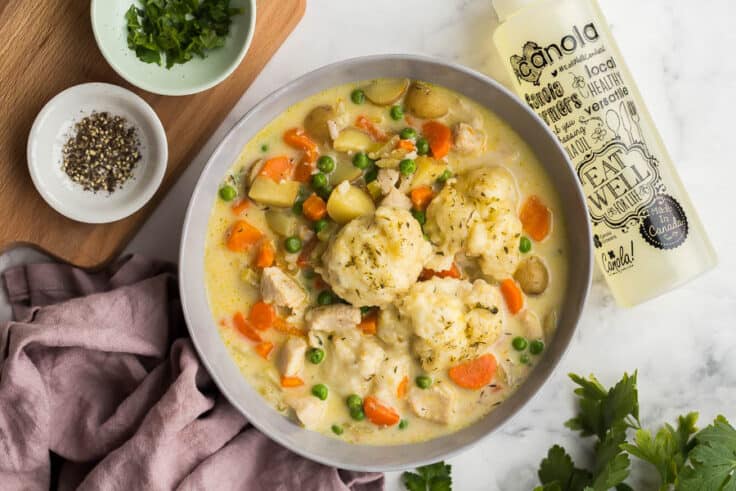 bowl of chicken and dumplings with canola oil bottle