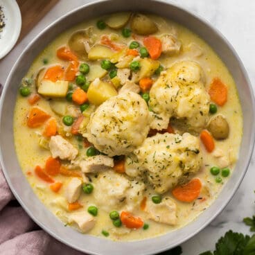 overhead image of chicken and dumplings in grey bowl