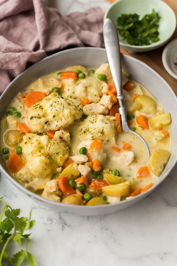 close up image of chicken and dumplings in bowl with spoon
