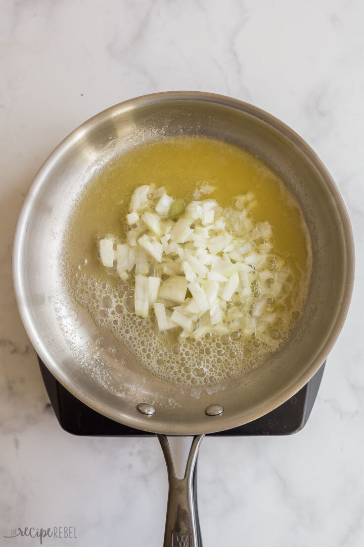 onions cooking in melted butter in stainless steel skillet