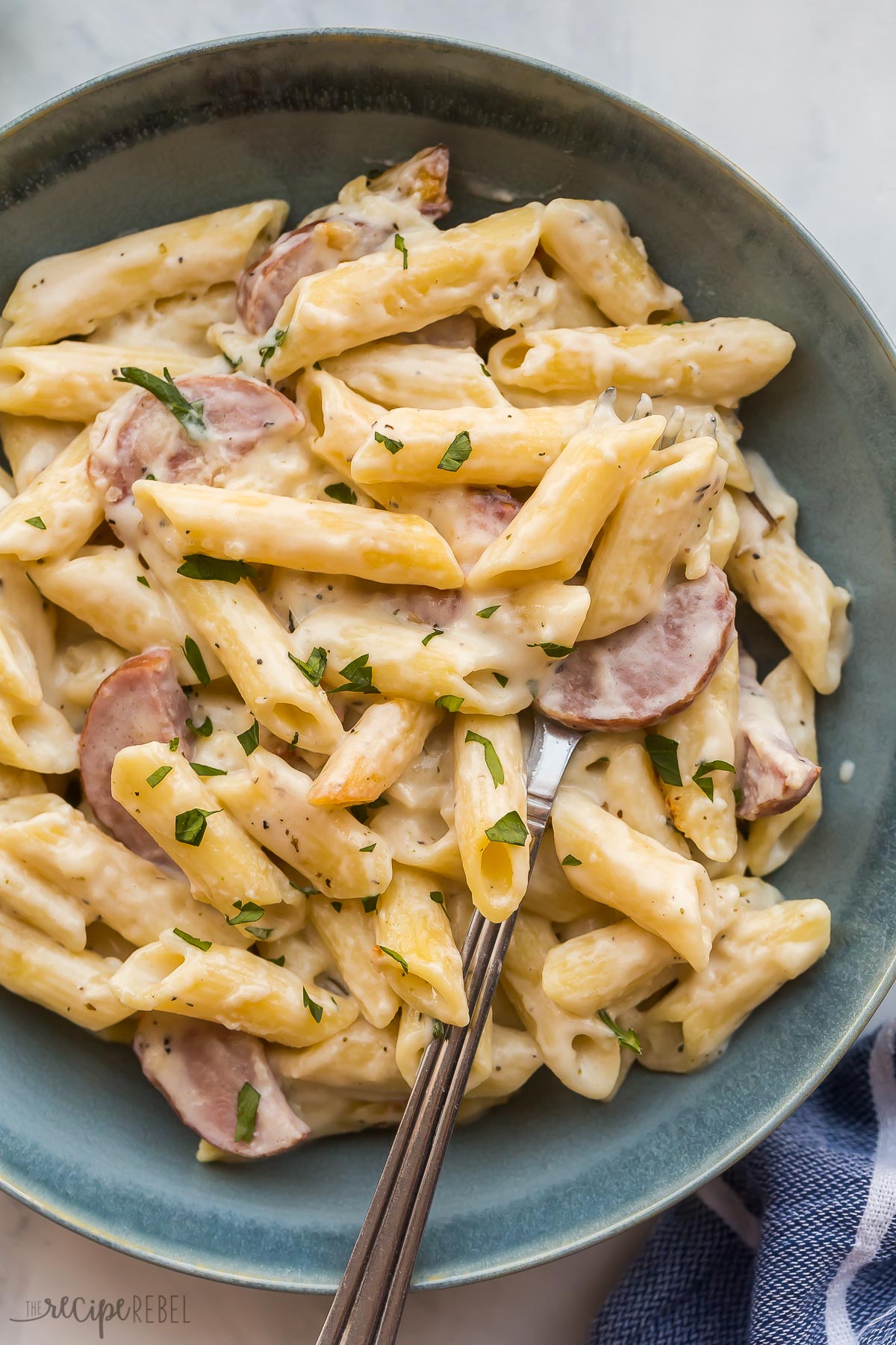 close up image of turkey kielbasa pasta bake in blue bowl