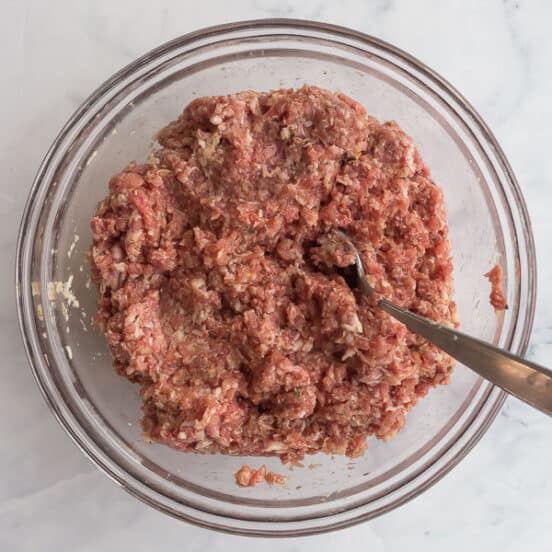 overhead image of mixed meatball mixture in glass bowl