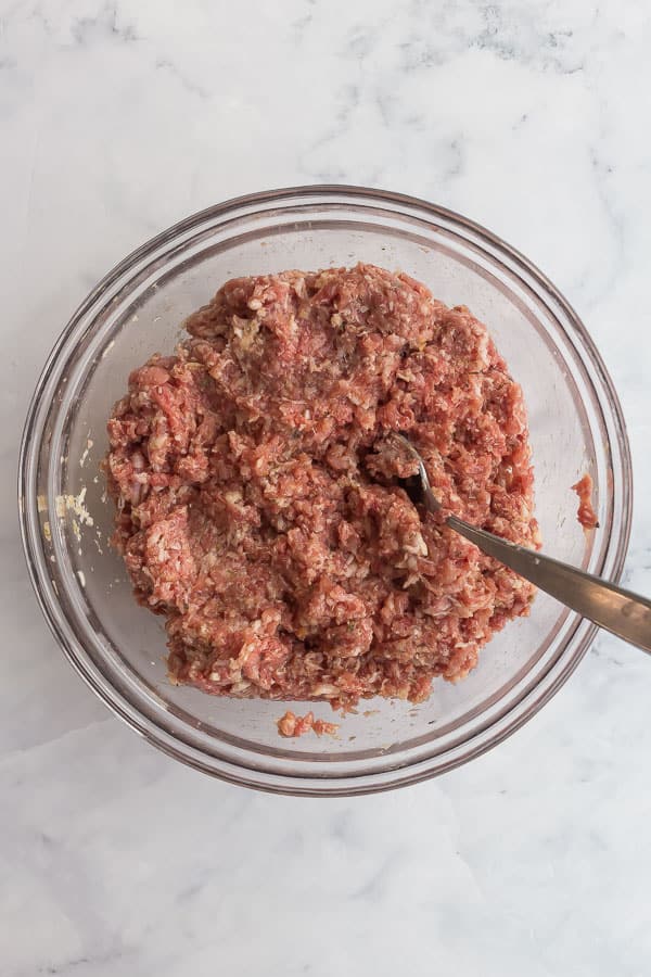 overhead image of mixed meatball mixture in glass bowl