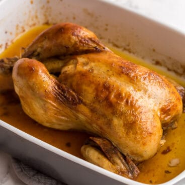 square image of perfect roast chicken in baking dish.