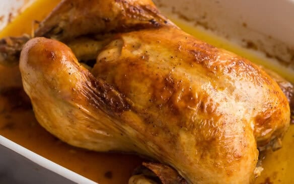 square image of perfect roast chicken in baking dish.