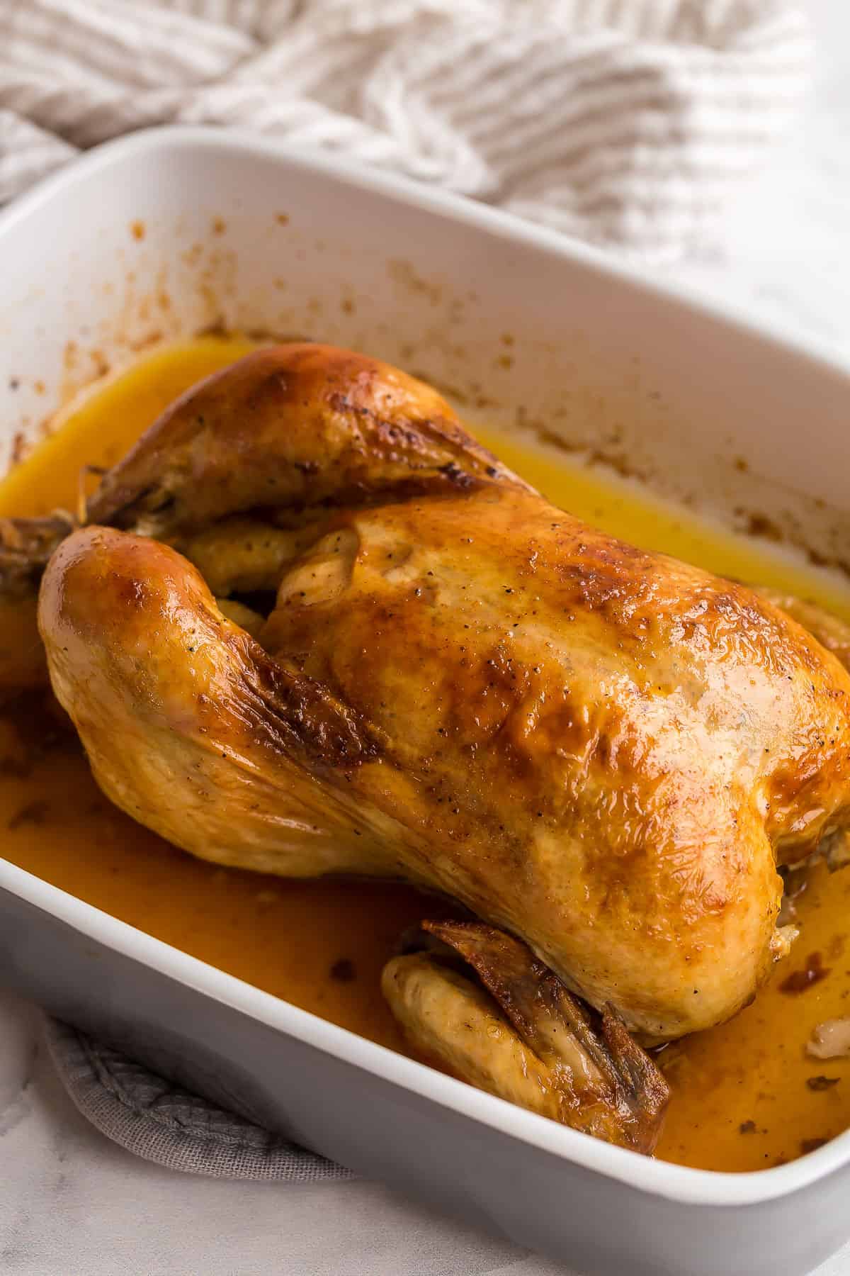perfect golden roast chicken in a grey baking dish.