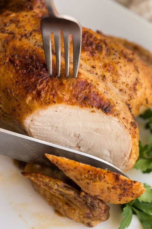 breast of roast chicken being sliced