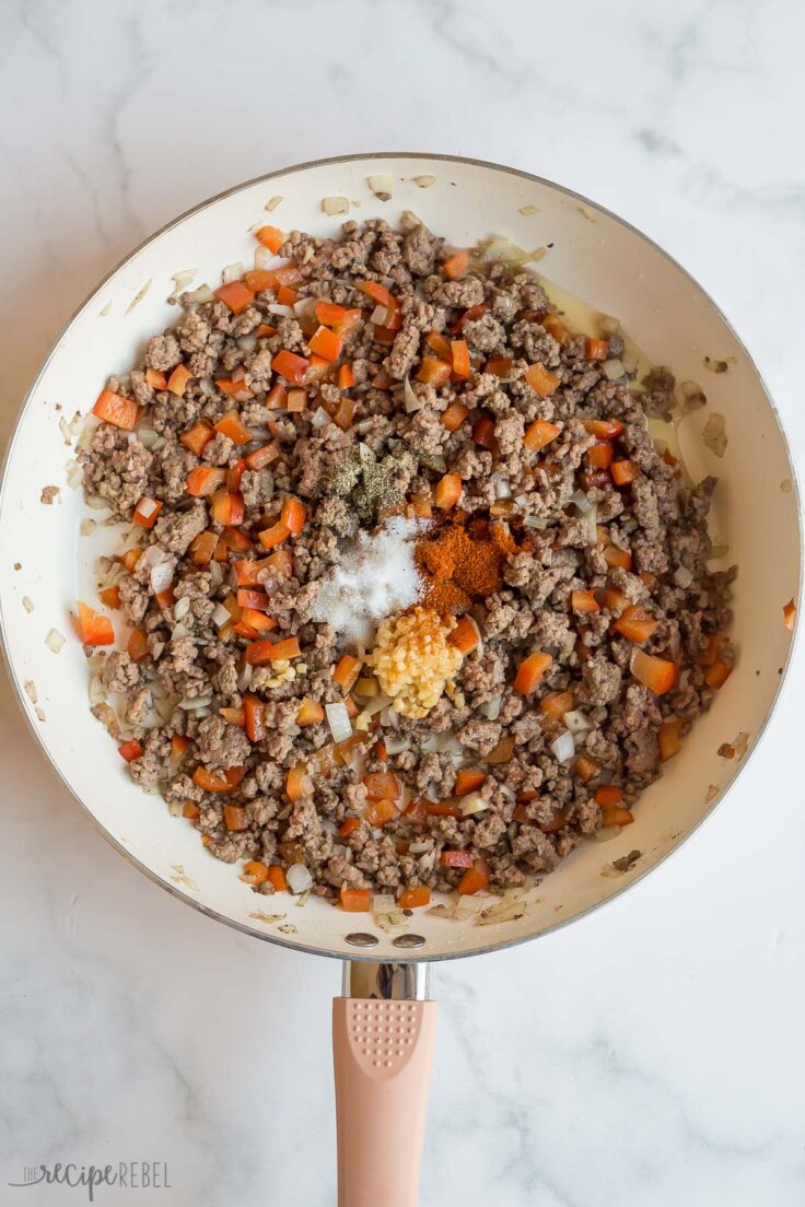 seasonings added to cooked ground beef in skillet