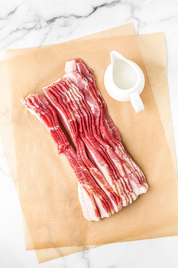 slices of raw bacon on parchment paper