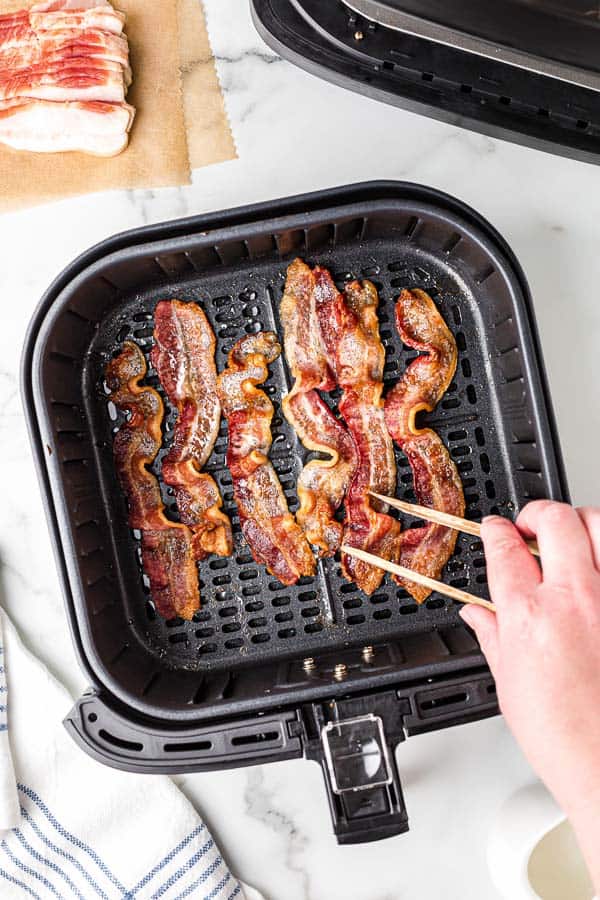 using tongs to flip bacon in air fryer