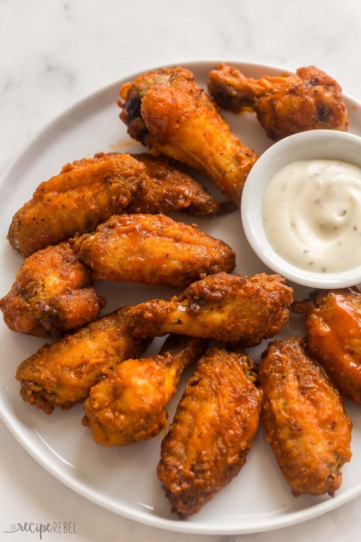 air fryer chicken wings coated in buffalo sauce on white plate