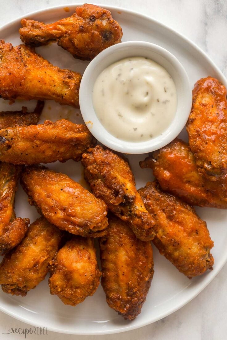 overhead close up image of air fryer chicken wings on white plate with ranch dip