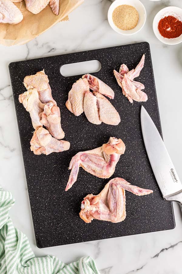 whole chicken wings on cutting board with knife