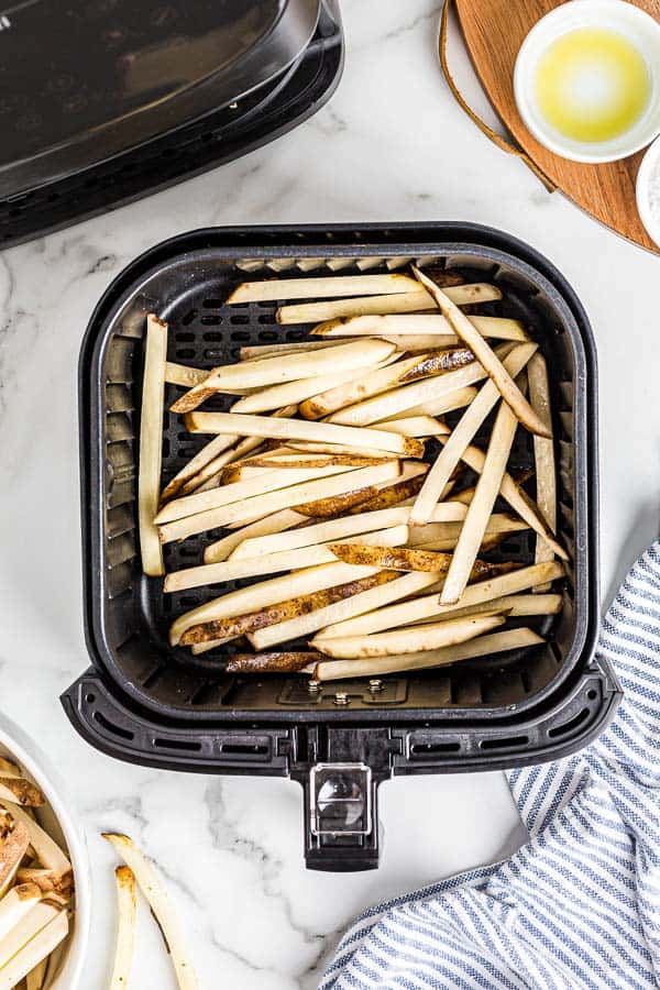 uncooked potatoes in air fryer basket