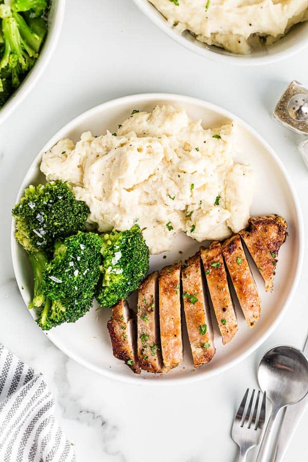 overhead image of plate with sliced pork chop and mashed potatoes