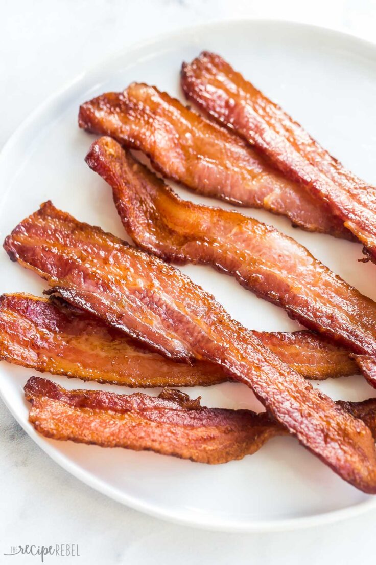 six strips of air fryer bacon on a white plate