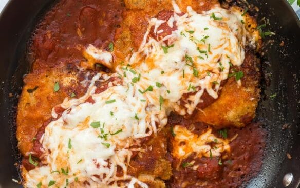 overhead image of chicken parmesan in black pan