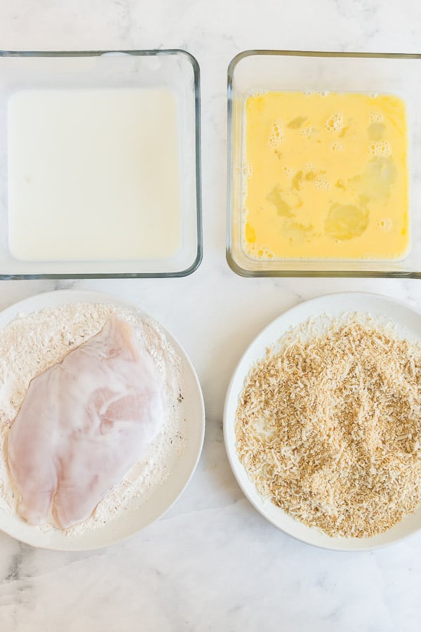 four dishes with all components for breading chicken