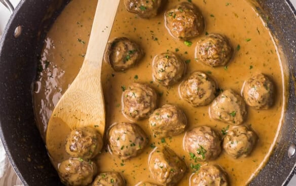 overhead image of swedish meatballs in gravy in black pan