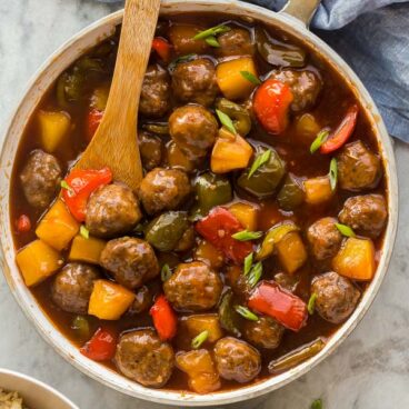overhead image of sweet and sour meatballs with sauce in white pan
