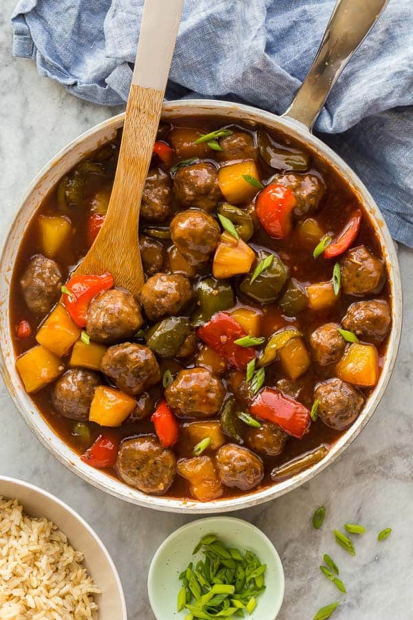 overhead image of sweet and sour meatballs with sauce in white pan