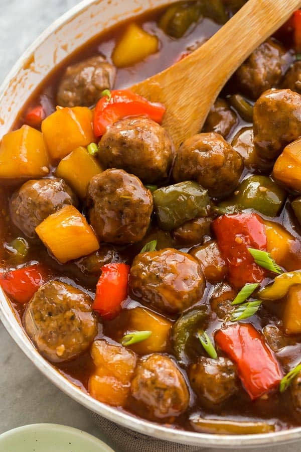 close up image of meatballs in pan with peppers and pineapple