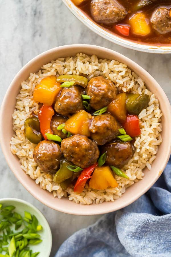 overhead image of bowl of rice with sweet and sour meatballs on top