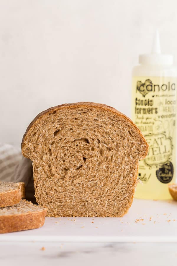 loaf of whole wheat bread with canola oil bottle in the background