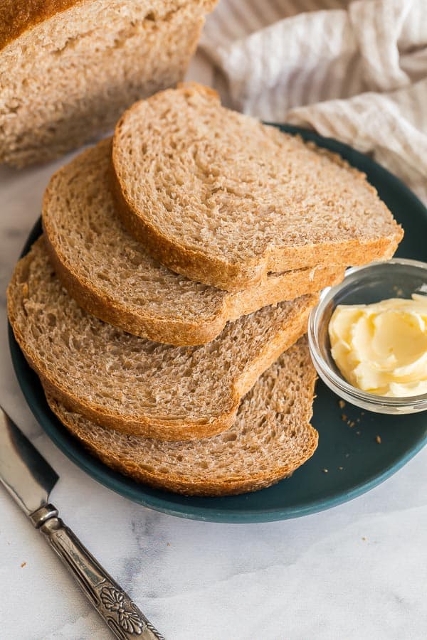 four slices of whole wheat bread on plate with butter