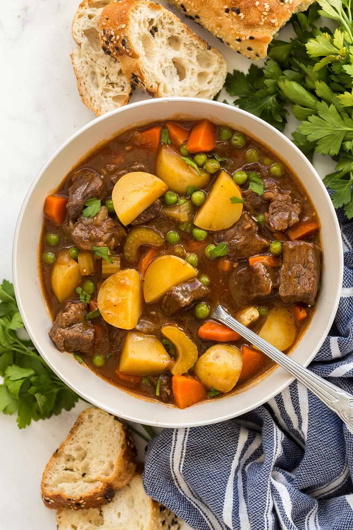 overhead image of beef stew in a bowl with a spoon.