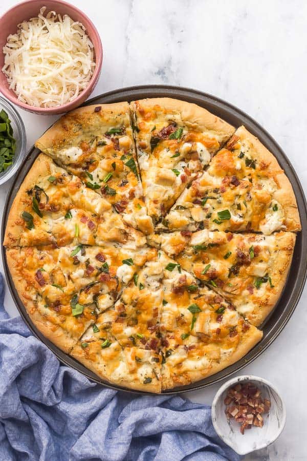 overhead image of chicken alfredo pizza on white background