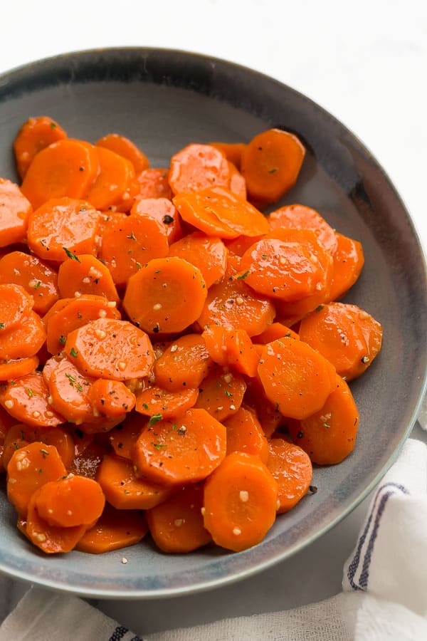 close up of honey glazed carrots in blue bowl