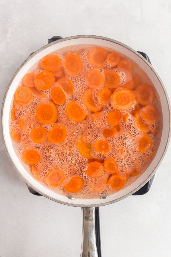 carrots in white pan with simmering water