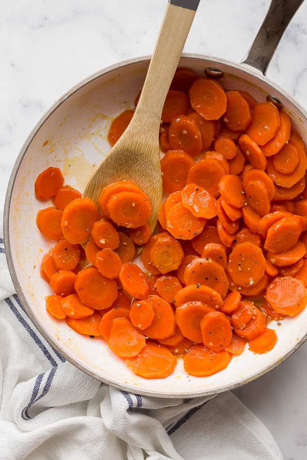 overhead image of glazed carrots in white pan