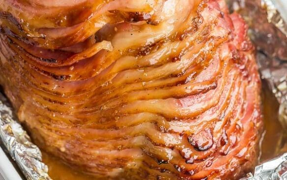 whole spiral ham in baking dish with honey glaze